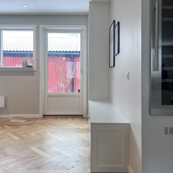 Inramade täcksidor i samma stil som köket ger rummet en helhet.