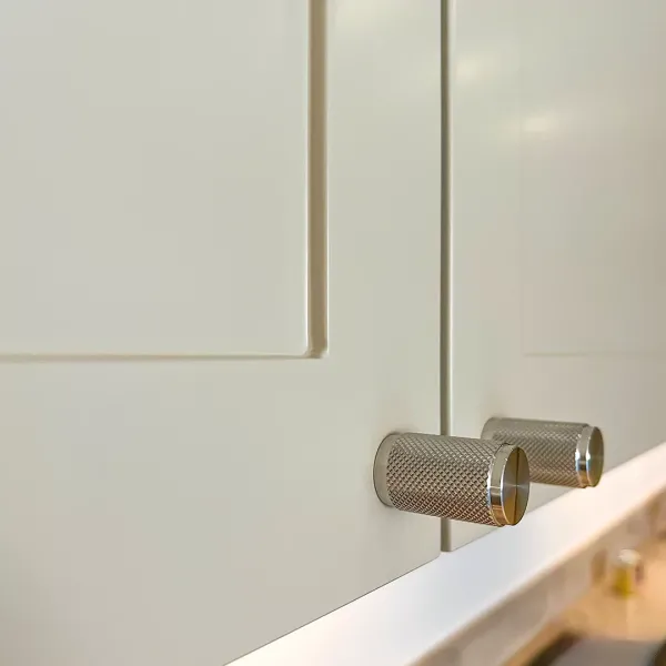 Förnicklade knoppar är en stilfull detalj som snyggt kompletterar det beiga köket.