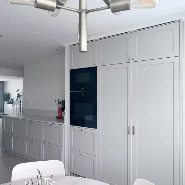 De kromade beslagen är en elegant detalj som gifter sig fint med de grå snickerierna.
